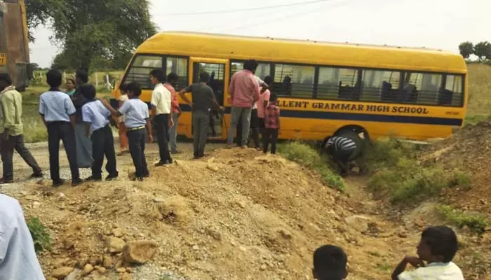 రోడ్డు కల్వర్టు లో పడ్డ స్కూల్ బస్సు