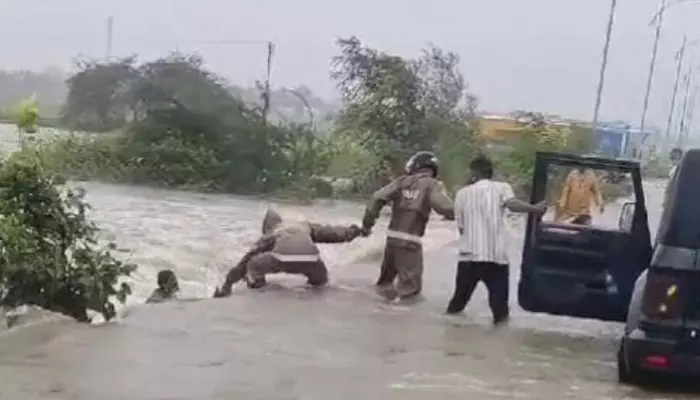 వరదలో కొట్టుకుపోతున్న వ్యక్తిని కాపాడిన ఇద్దరు కానిస్టేబుళ్లు