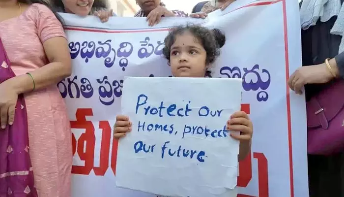 Protest : సీఎం సార్.. మా ఇల్లు మాకు కావాలి.. ప్లకార్డులతో చిన్నారుల నిరసన.. వైరల్