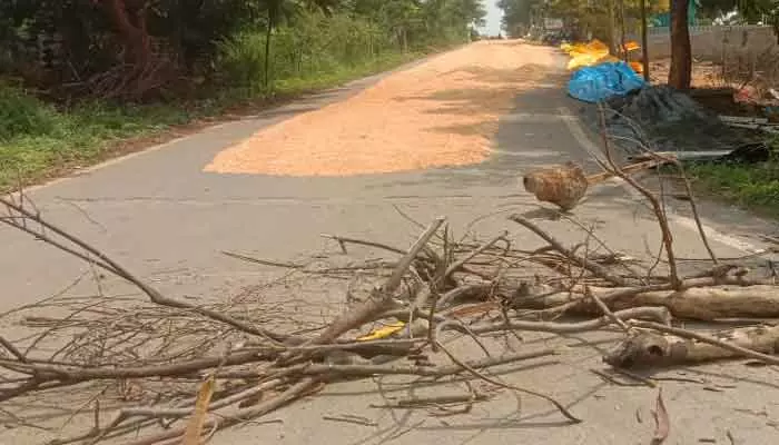 ధాన్యం ఆరబోత..రోడ్డు బ్లాక్ చేసిన రైతులు