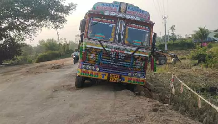 road accident : తృటిలో తప్పిన ప్రమాదం..రోడ్డు గుంతలో దిగబడిన లారీ